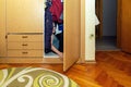 A little boy hiding in the wardrobe among the clothes. Royalty Free Stock Photo