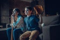 Little boy and his beautiful mother sitting on couch in living room with baseball bat and mitt while Royalty Free Stock Photo