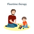 Little boy and a his father sitting on a floor and playing with blocks. Floortime therapy technique, used for teaching Royalty Free Stock Photo