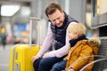 Little boy and his father waiting express train on railway station platform or waiting their flight at the airport Royalty Free Stock Photo