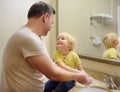 Little boy and his father washing their hands with soap in bathroom together. Hygiene for little child Royalty Free Stock Photo