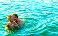 The little boy in his father& x27;s arms, in the waves of the sea. Dad with the little child on vacation. Royalty Free Stock Photo