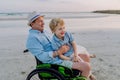 Little boy with his granfather on wheelchair, having fun and enjoying sea together. Royalty Free Stock Photo