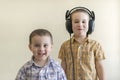 A little boy with his headphones dances with his brother. Two little brothers in shirts amuse themselves and dance. Royalty Free Stock Photo