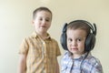 A little boy with his headphones dances with his brother. Two little brothers in shirts amuse themselves and dance. male Royalty Free Stock Photo