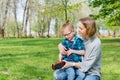 A little boy and his mom play with a toy car in the park in spring Royalty Free Stock Photo