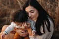 Little boy and his mother walking in the autumn park. Mother hugs her toddler boy Royalty Free Stock Photo