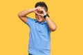 Little boy hispanic kid wearing casual clothes doing heart shape with hand and fingers smiling looking through sign Royalty Free Stock Photo