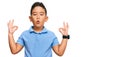 Little boy hispanic kid wearing casual clothes looking surprised and shocked doing ok approval symbol with fingers Royalty Free Stock Photo