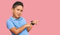 Little boy hispanic kid wearing casual clothes pointing aside worried and nervous with both hands, concerned and surprised Royalty Free Stock Photo
