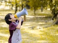 Little boy hold megaphone shouting in the park