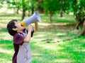 Little boy hold megaphone shouting in the park