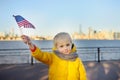 Little boy holding the American flag on the background skyscrapers of Manhattan Royalty Free Stock Photo