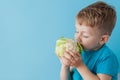 Little Boy Holding Broccoli in his hands on blue background, diet and exercise for good health concept Royalty Free Stock Photo