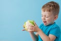 Little Boy Holding Broccoli in his hands on blue background, diet and exercise for good health concept Royalty Free Stock Photo