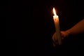 Little boy holding a candle in the dark ,faith and religion ,prayer