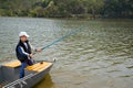 Little Boy Holding A Fishing Rod And Fishing From Wooden Boat On The Lake Royalty Free Stock Photo