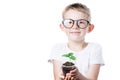 Little boy holding a glass with a small plant