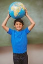 Little boy holding globe over head