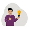 A little boy is holding a light bulb in his hand. Concept of idea, brainstorming, thinking, solution, eureka, bingo Royalty Free Stock Photo
