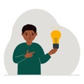 A little boy is holding a light bulb in his hand. Concept of idea, brainstorming, thinking, solution, eureka, bingo Royalty Free Stock Photo