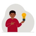 A little boy is holding a light bulb in his hand. Concept of idea, brainstorming, thinking, solution, eureka, bingo