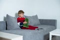 Little boy holding plush toy and sitting on sofa