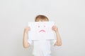 Little boy holding sad face mask Royalty Free Stock Photo