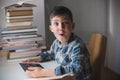 Little boy is holding a tablet and looks suprised.