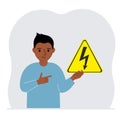 A little boy is holding a yellow warning sign with a black lightning in his hand. The concept of the danger of electric Royalty Free Stock Photo