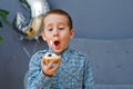 A little boy holds a birthday cake with a lit candle in his hands. Close-up, blowing on a candle. Happy birthday concert. Festive Royalty Free Stock Photo