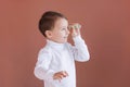 A little boy holds in his hands one dollar on a pink background, the joy of the first earnings Royalty Free Stock Photo