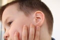 Little boy holds on to the ear, part of the face close-up, medical concept, hearing control, middle ear inflammation, otitis media Royalty Free Stock Photo