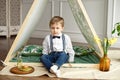 A little boy in holiday clothes is sitting in a tent in his room Royalty Free Stock Photo