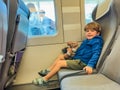 Little boy hug plush toy seating by a train window Royalty Free Stock Photo