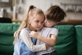 Little boy brother consoling and supporting upset girl embracing