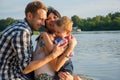 Little boy hugs his dad and mom and they smiling in outdoors Royalty Free Stock Photo