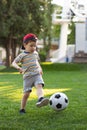Little boy hugs a soccer ball and plays soccer in the summer in the park on the nature Royalty Free Stock Photo