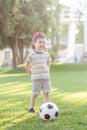 Little boy hugs a soccer ball and plays soccer in the summer in the park on the nature. Royalty Free Stock Photo