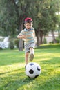 Little boy hugs a soccer ball and plays soccer in the summer in the park on the nature Royalty Free Stock Photo