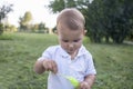 Little boy inflates and bursts soap bubbles. Cute funny kid is playing with soap bubbles in the park. Place for text Royalty Free Stock Photo