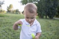 Little boy inflates and bursts soap bubbles. Cute funny kid is playing with soap bubbles in the park. Place for text Royalty Free Stock Photo