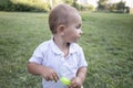 Little boy inflates and bursts soap bubbles. Cute funny kid is playing with soap bubbles in the park. Place for text Royalty Free Stock Photo