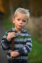 Little boy int he autumn nature holding plant typha