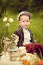 Little boy in a jacket and plaid pants to sit on the cushion, ne