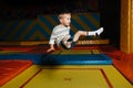 Little boy jumping high on a square trampoline in entertainment center Royalty Free Stock Photo