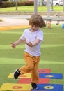 Little boy jumping by hopscotch drawn. Boy playing hopscotch game on playground on spring day. Royalty Free Stock Photo