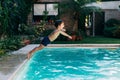 Little boy jumping in a pool. Child get fun in the swimming pool of his home. Outdoors activities in quarantine Royalty Free Stock Photo