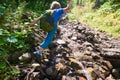 Little boy jumps over a stream in a forest Royalty Free Stock Photo