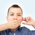 Little boy, kid covered his mouth with his palm, bit his tongue, stomatitis, clings to his ear, close-up, medical concept, autism Royalty Free Stock Photo